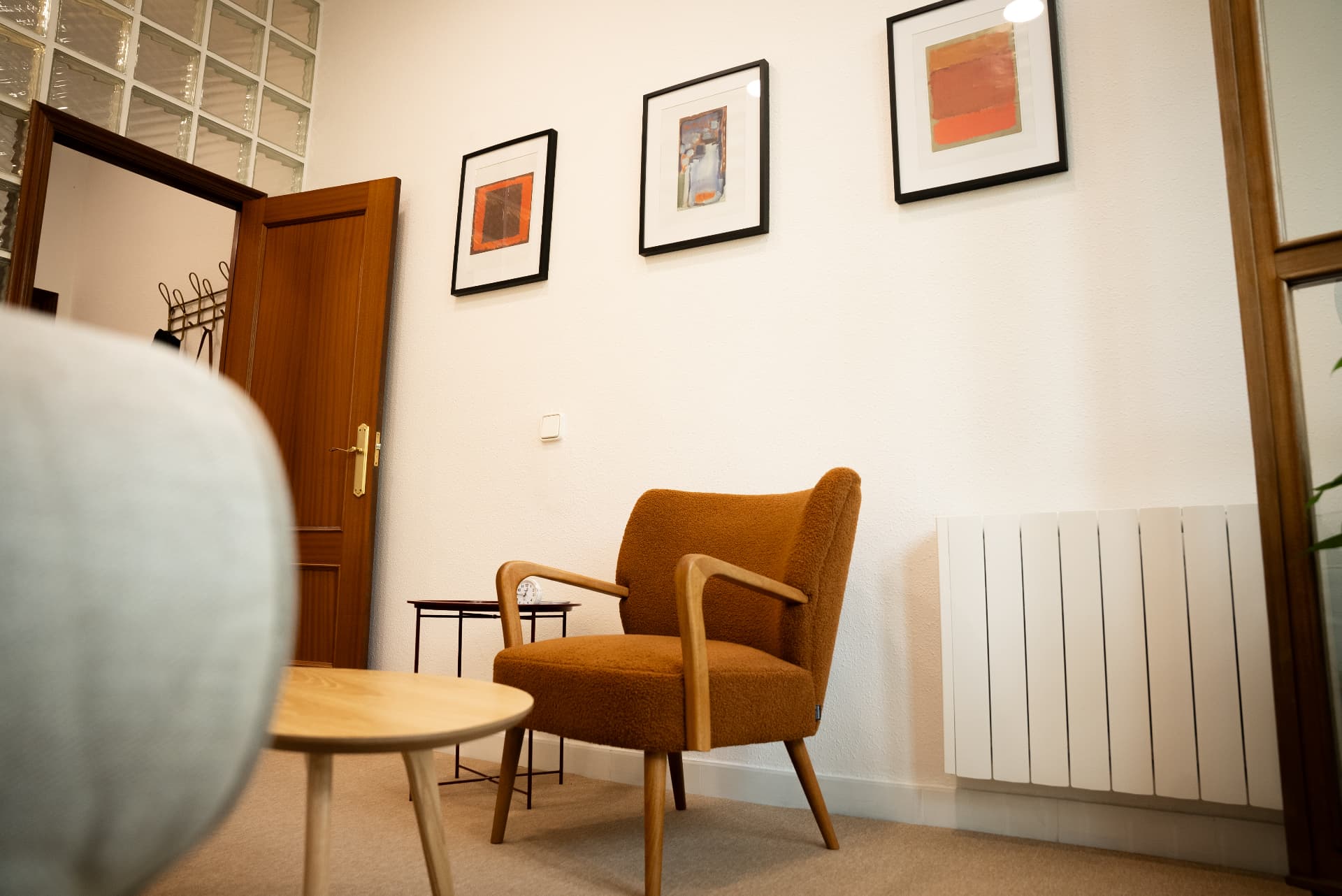 Sillón de la consulta junto a cuadros de tonos cálidos